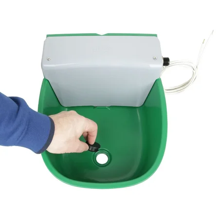 Grüne Reinigungsspülwanne mit grauem Deckel; Hand betätigt schwarzen Knopf am Boden, rechts eine Kabelverbindung sichtbar.