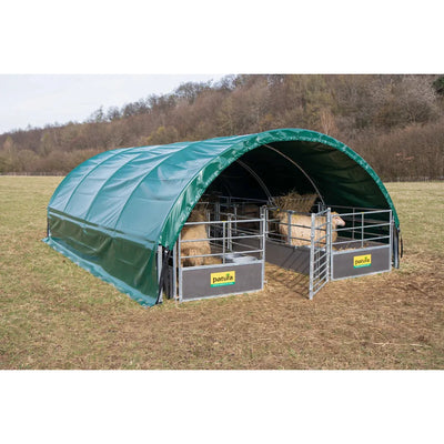 Grünes halbrundes Schafzelt auf der Weide, zwei Metall-Schafgehege mit Heu und Schafen, Patura-Markenschild an den Gehegen, Wald im Hintergrund.