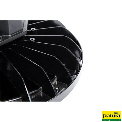 Nahaufnahme eines schwarzen runden Lüftergehäuses mit radial angeordneten Lamellen aus Kunststoff auf weissem Hintergrund; Patura-Logo unten rechts.