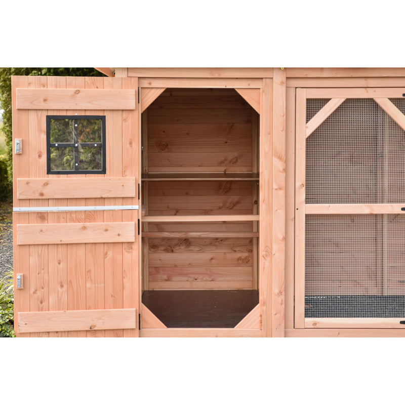 Offener Hühnerstall aus Naturholz mit Innenregalen; links ein kleines Fenster mit schwarzem Metallrahmen, rechts eine Drahtgitterseite.