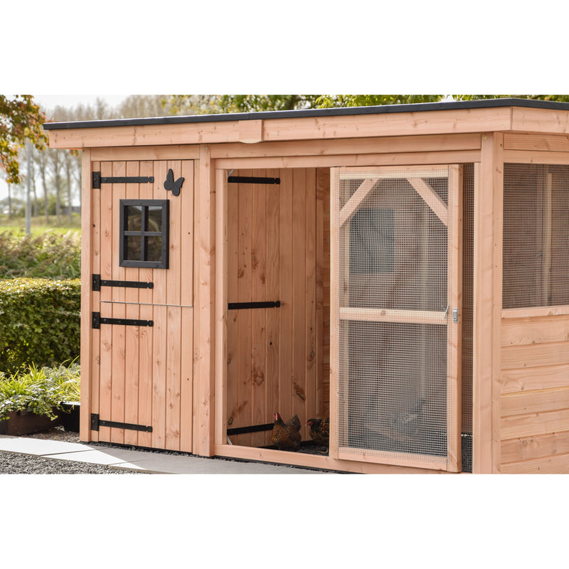 Holz-Hühnerstall mit offener Tür, kleinem schwarzen Fensterrahmen und Drahtgitterbereich rechts; zwei Hühner stehen im Eingang; Gartenlandschaft im Hintergrund.