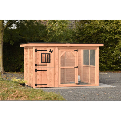 Holz-Hühnerstall mit Drahtgehege (Auslauf), Tür- und Fensterrahmen aus schwarzem Metall, sitzt auf Kiesboden vor Bäumen.