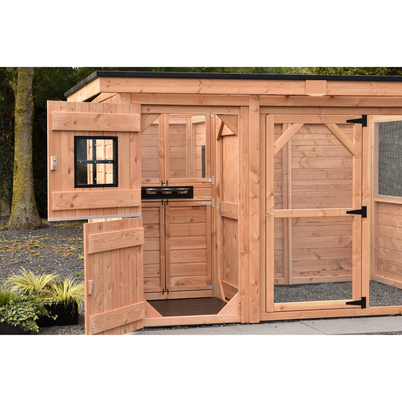 Grosser Hühnerstall aus Holz mit Auslaufgehege und Drahtgitter; geöffneten Türen und Fensterrahmen; Gartenumgebung mit Bäumen.