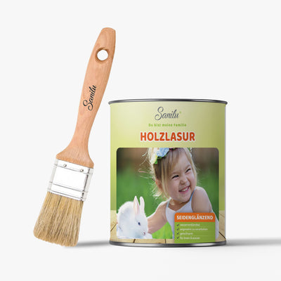 Holzlasur-Seidenglänzend Dose von Sanilu mit Holzpinsel daneben; grüne Verpackung zeigt ein lachendes Mädchen mit Kaninchen auf dem Etikett.