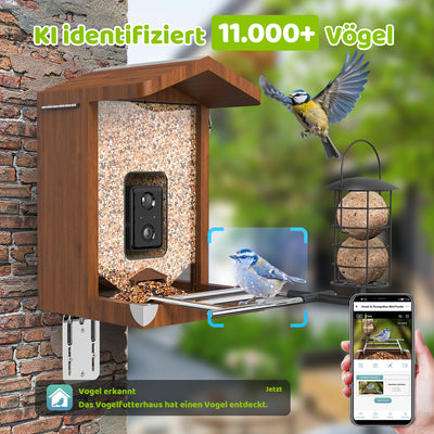Smartes Vogel-Futterhaus aus Holz mit Steinbehälter, integrierter Kamera und Futterteller; ein Vogel landet am Futterplatz, während ein Smartphone eine KI-Vogelerkennung anzeigt (Anzeige „KI identifiziert 11.000+ Vögel“).