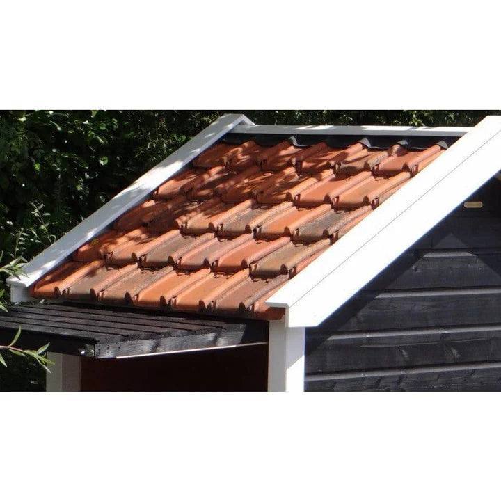 Gartenhaus mit orange-braunen Tonziegeln, weissem Dachrand und dunkler Holzwand; grüne Bäume im Hintergrund.