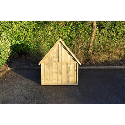 Kleines Holzspielhaus aus Naturholz vor grüner Hecke auf asphaltiertem Untergrund.