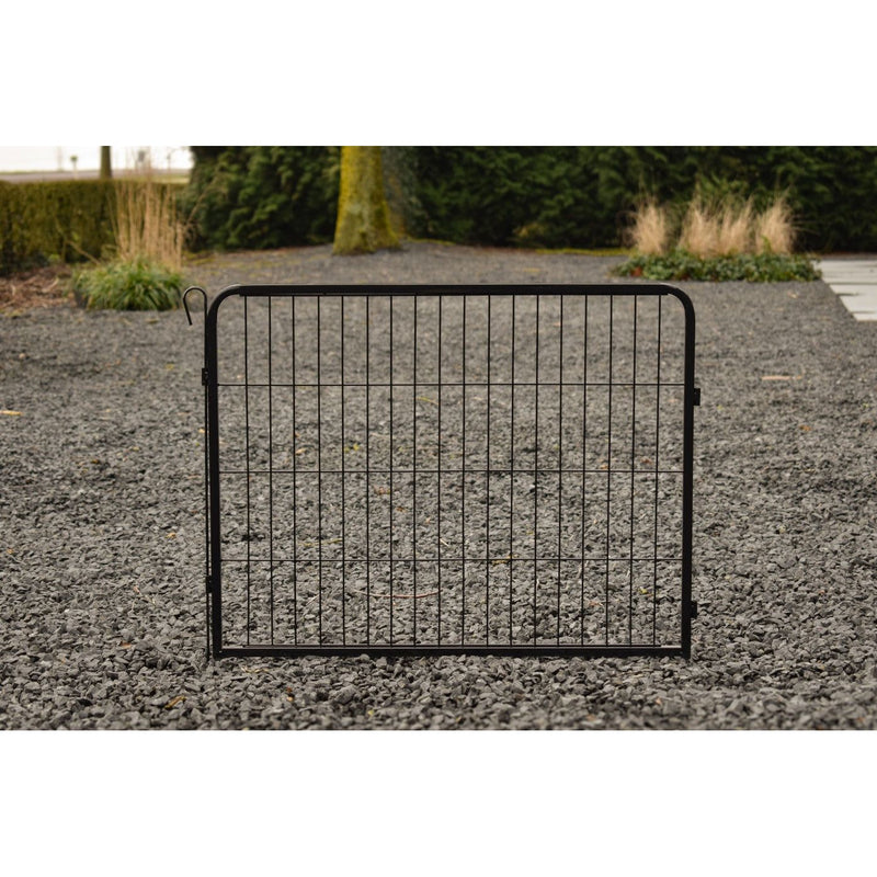 Schwarze Metall-Gitterbarriere liegt auf Kies, Hintergrund mit Bäumen und Gräsern.
