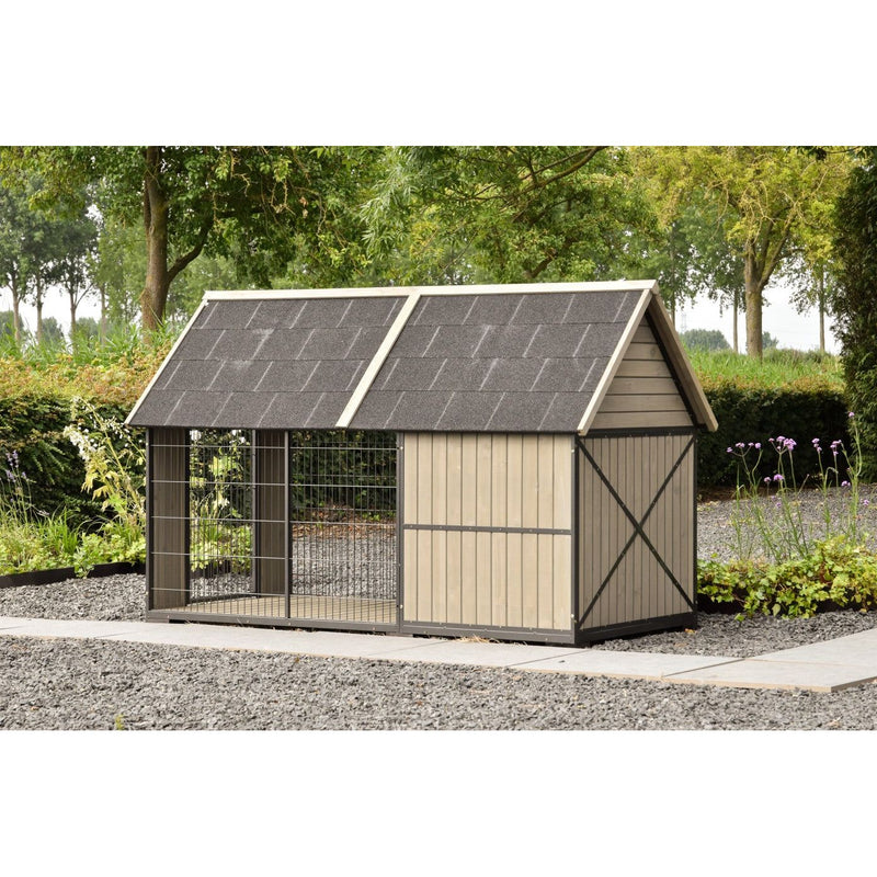 Hundezwinger aus Holz mit Drahtgittertür, seitlichen Holzwandpaneelen und grauem Schindeldach im Garten mit Bäumen und Kiesweg.