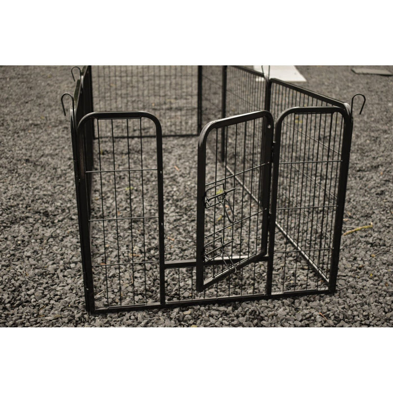 Schwarzer Metall-Gitterkäfig für Haustiere mit Tür, auf Kiesboden.