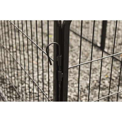 Nahaufnahme eines schwarzen Metallzauns mit gebogenem Verriegelungshaken am Pfosten; im Hintergrund Kieselsteine.