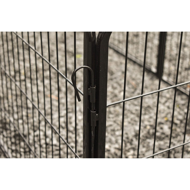 Nahaufnahme eines schwarzen Metallzauns mit gebogenem Verriegelungshaken am Pfosten; im Hintergrund Kieselsteine.