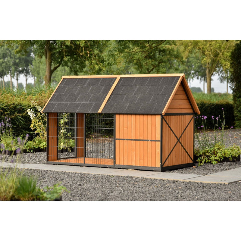 Holz-Hundehütte im Garten mit Drahtgitterfront, dunklem Schindeldach und seitlicher Holzwand, auf Kiesboden mit Bäumen im Hintergrund.