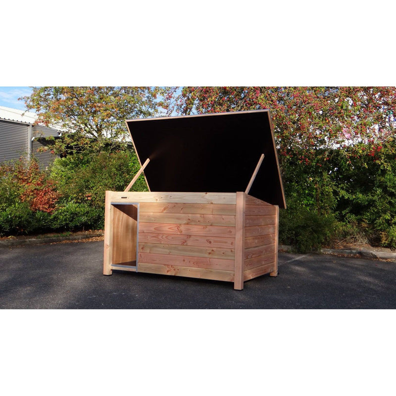 Offene Holzkiste als Garten-Aufbewahrungsbox aus Naturholz mit aufgeklapptem Deckel, umgeben von Bäumen und Sträuchern.