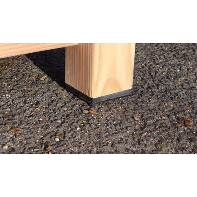 Nahaufnahme eines Holzmöbelbeins mit schwarzem Gummi-Fuss auf rauem Asphalt.