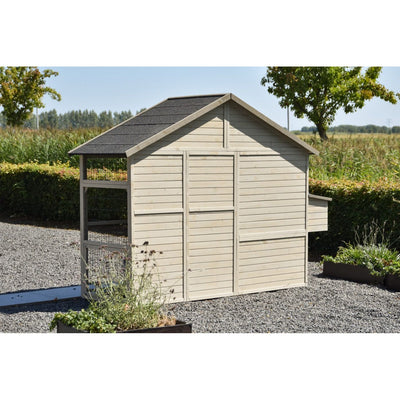 Holz-Gartenhütte mit Satteldach und angeschlossenem Kleintierauslauf aus Drahtgitter, steht auf Kiesboden in einem Garten mit Sträuchern und Bäumen im Hintergrund.