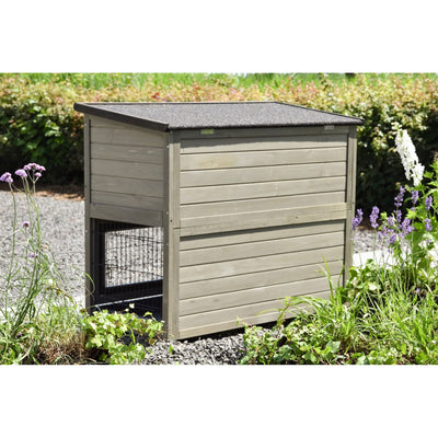 Garten-Hundehütte aus Holz mit dunklem Dach, seitlichem Drahtgittereingang, umgeben von Blumen.