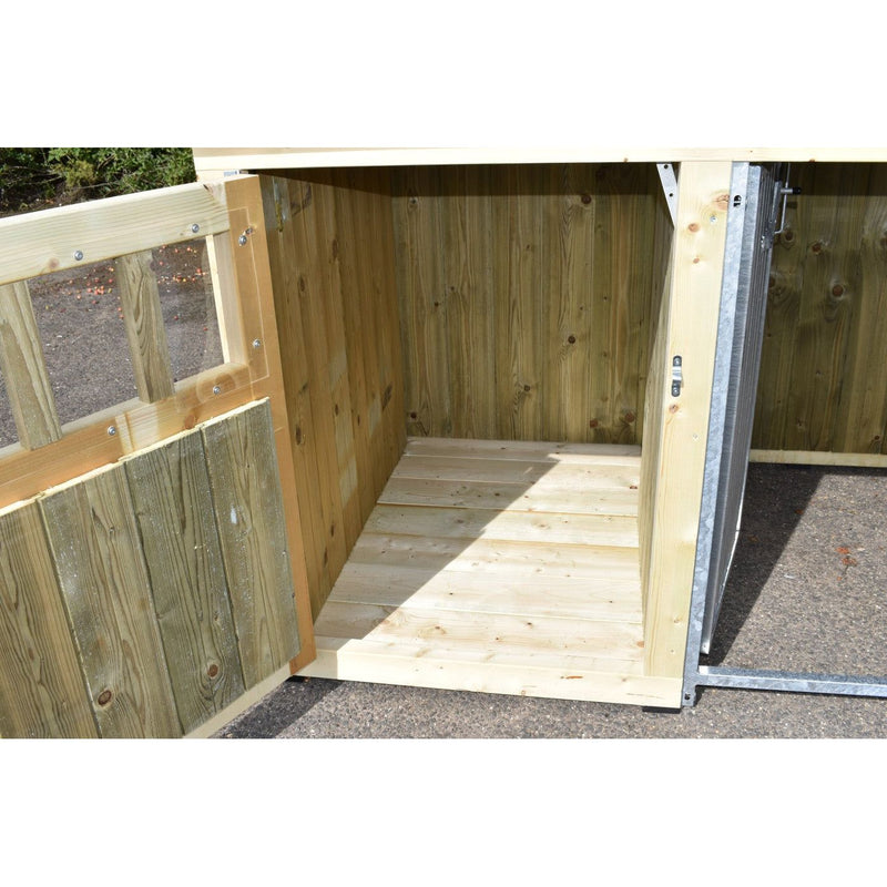 Offener Holzunterstand im Garten aus unbehandeltem Holz mit Holzboden und Innenwänden, steht auf asphaltiertem Untergrund.