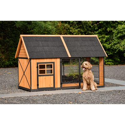 Holz-Hundehütte mit schwarzem Dach und Drahtauslauf; brauner Hund sitzt vor der Hütte im Garten.