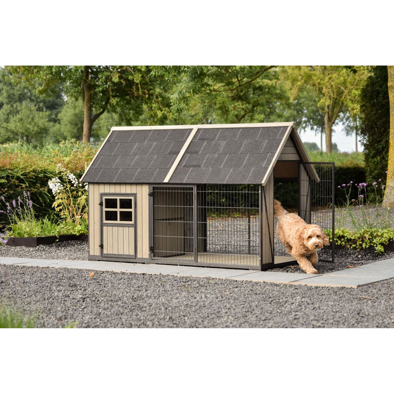 Braun-cremiger Hund verlässt einen Holz-Hundekennel mit Drahtgitter im Garten; Gehege mit dunklem Schindeldach, umliegende Kieswege, Pflanzen und Bäume.