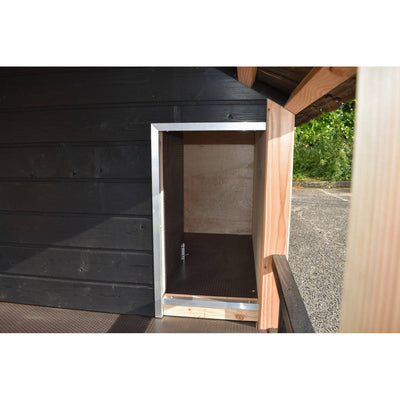 Offener kleiner Outdoor-Speicher oder Schrank aus Holz mit Aluminiumrahmen vor einer schwarzen Holzwand; Innenraum aus Holz, Bodenplatte sichtbar, Gartenzugang im Hintergrund.