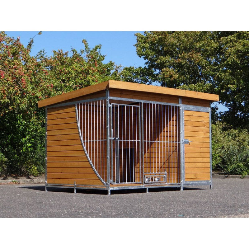 Grosser Hundekäfig aus Holz und Metall mit Gittertür, steht im Garten vor Bäumen und blauem Himmel.