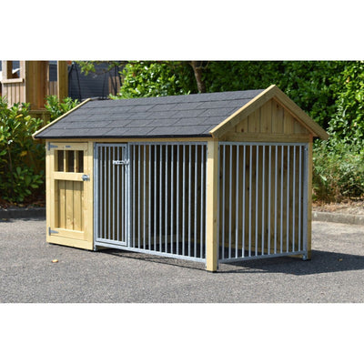 Holz-Hundezwinger mit Metallgitterfront, Satteldach und Holztür, steht auf Asphalt im Garten.