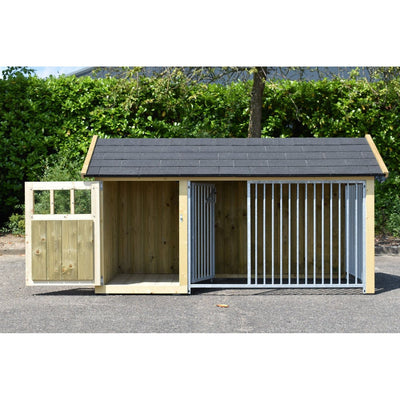 Hundehaus mit zwei Abschnitten: links geschlossene Holzkammer, rechts Zwinger aus Metallstäben; dunkles Schindeldach; Holzkonstruktion auf Asphalt vor einer grünen Hecke.
