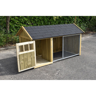 Grosser Holz-Hundezwinger mit dunklem Schindeldach, links offenes Holztor, mittlerer Innenraum aus Holz, rechts abgetrennte Hundebox mit Metallgitter; steht auf Asphalt vor grüner Hecke.
