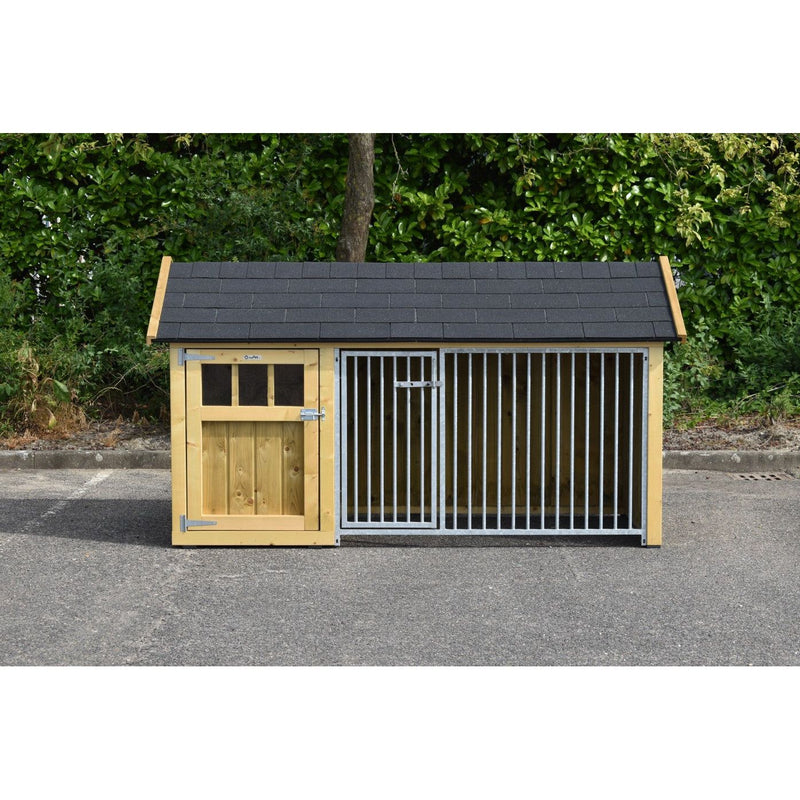 Holz-Hundezwinger mit Schieferdach; linke Holztür mit Fenster, rechte breite Metallgittertür; steht auf Asphalt vor grünem Buschwerk.