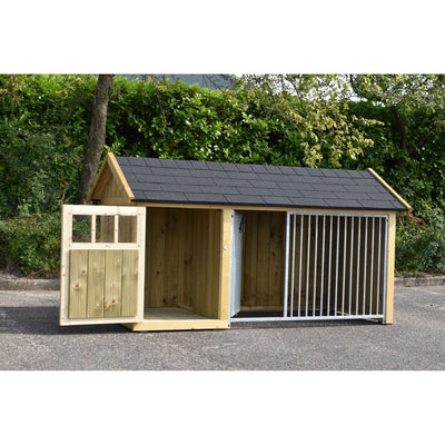 Holz-Hundehütte mit zwei Bereichen: links geschlossener Innenraum, rechts offener Zwinger aus Metall, dunkles Schindeldach, auf Asphaltboden, von Grün umgeben