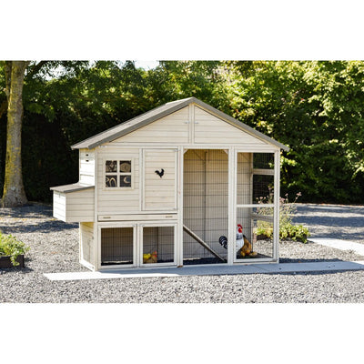 Holz-Hühnerstall mit Auslaufgehege aus Drahtgitter, roter Hahn und Hühner im Gehege, umgeben von Kies und grünem Garten.