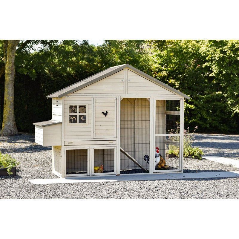 Holz-Hühnerstall mit Auslaufgehege aus Drahtgitter, roter Hahn und Hühner im Gehege, umgeben von Kies und grünem Garten.