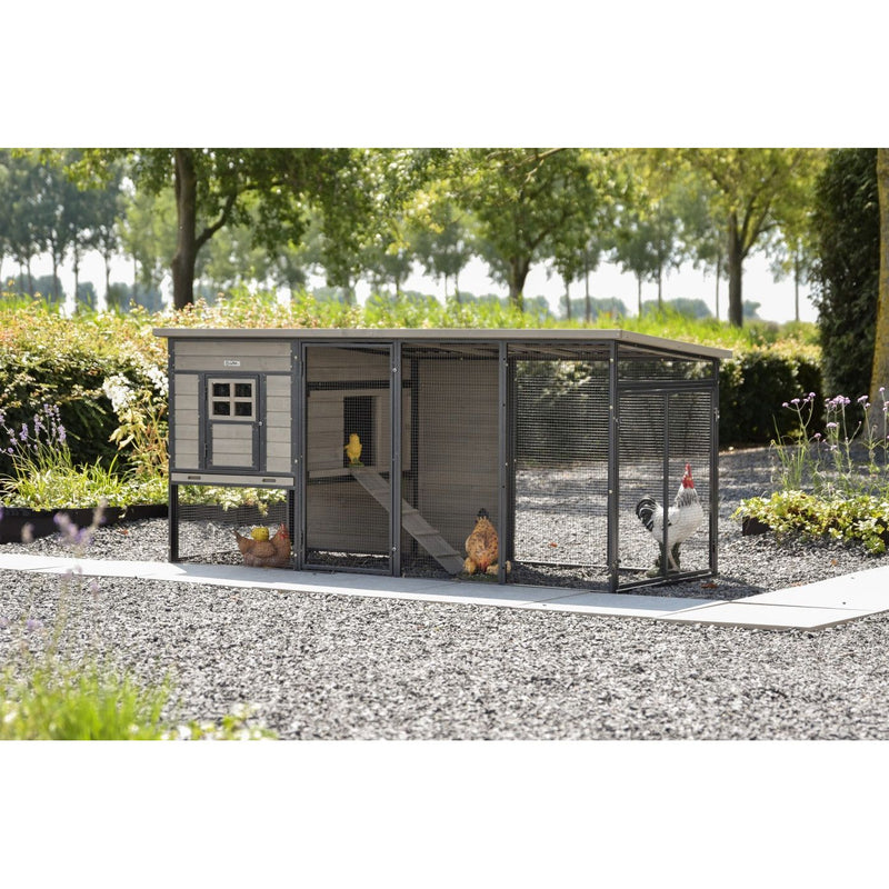 Moderner Hühnerstall mit Auslauf im Garten; Holzhaus mit Drahtgehege, Kiesboden und mehreren Abteilen, Hühnern im Freilauf.