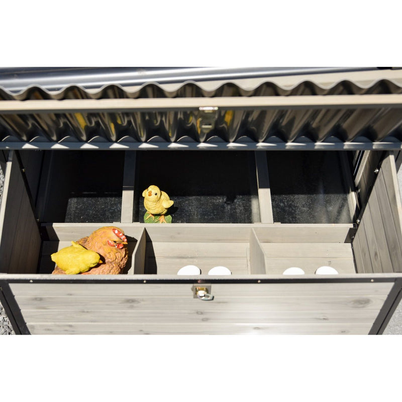Holz-Hühnerstall mit Fächern und Metall-Dach; drei weisse Eier in der unteren Kammer; zwei gelbe Spielküken im Inneren.