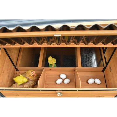 Offene Holzkiste mit Fächern: links braune Hennenfigur mit gelbem Küken, mittig drei weisse Eier, rechts zwei weitere weisse Eier.