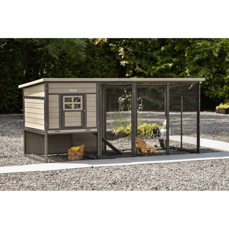 Hühnerstall mit kleinem Haus und Drahtgehege; mehrere Hühner und ein Hahn im Auslauf auf Kiesboden.