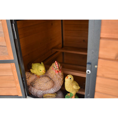 Garten-Holzschuppen mit Hühner-Deko: braune Henne und zwei gelbe Küken-Figuren.