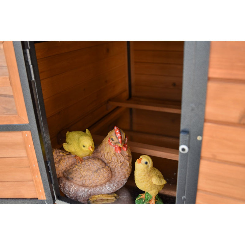 Garten-Holzschuppen mit Hühner-Deko: braune Henne und zwei gelbe Küken-Figuren.