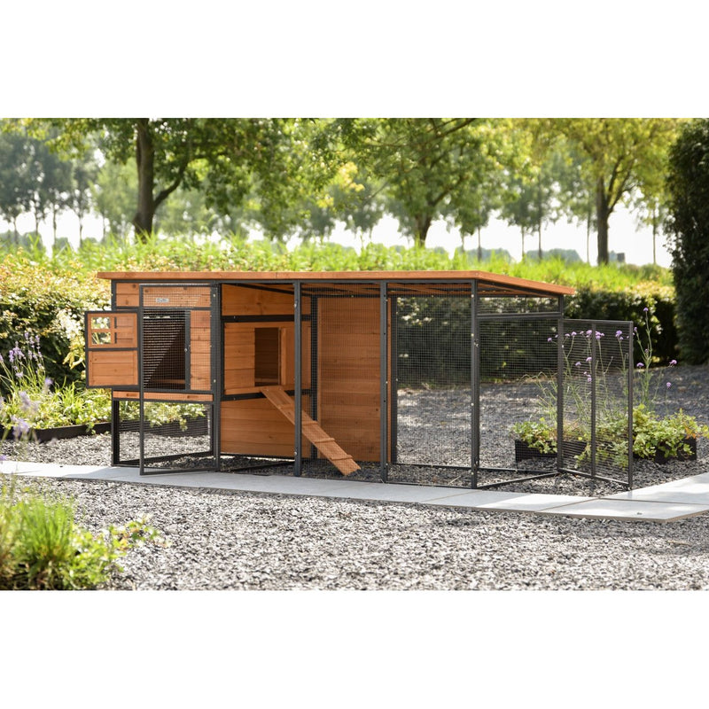 Hühnerstall mit Auslauf aus Holz und Drahtgeflecht im Garten, auf Kiesboden, von Bäumen und Grün umgeben.