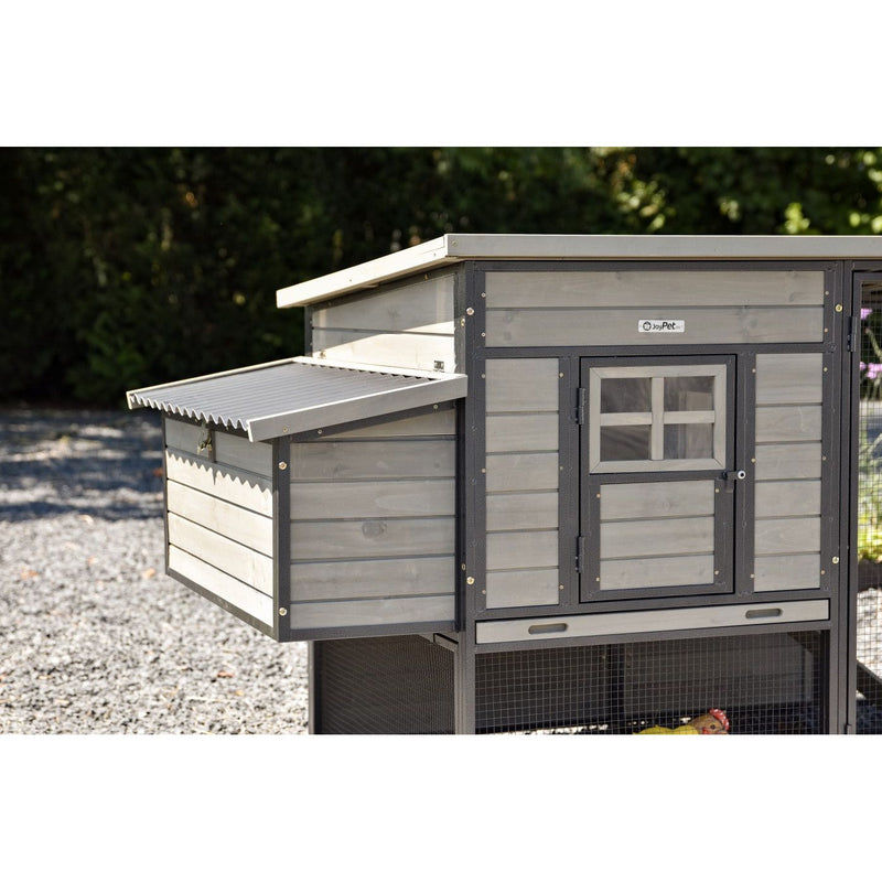 Grauer Holzhühnerstall mit seitlicher Nestbox, Fronttür mit Fenstergitter und Netzboden im Garten