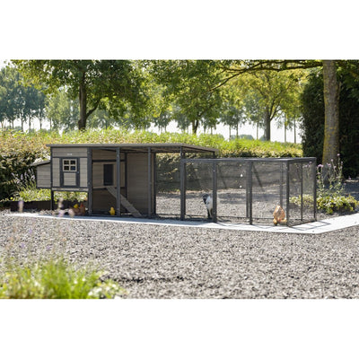 Hühnerstall mit angeschlossenem Drahtgitter-Auslauf im Garten, Kiesboden, umgeben von Bäumen; Hühner im Gehege.