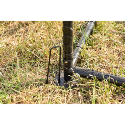 Metallbodenanker im Gras: Vertikaler Stab mit Erdanker und daneben schwarzer Gartenschlauch auf dem Boden.