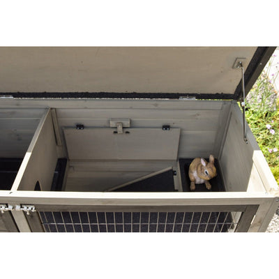 Offener Gartenkäfig mit Drahtgitterfront; im Innenraum sitzt ein braun-weisser Plüschtierhase in der rechten Ecke.