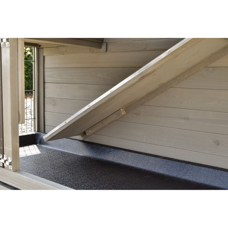 Innenansicht eines Holzspielhauses mit diagonal an der Wand befestigter Rampenplatte, Holzwandverkleidung und schwarzem rutschfestem Boden.