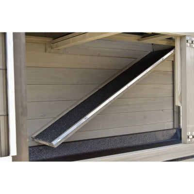 Diagonale Metallrampe mit schwarzem rutschfestem Belag im Innenraum eines holzverkleideten Laderaums.