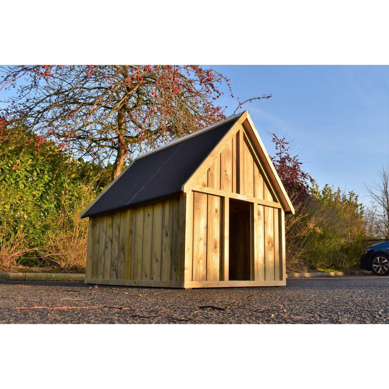 Gartenhaus aus Naturholz mit Satteldach, offener Eingang, steht auf Asphalt; umgeben von Bäumen und Gebüschen, blauer Himmel, rechts ein geparktes Auto.
