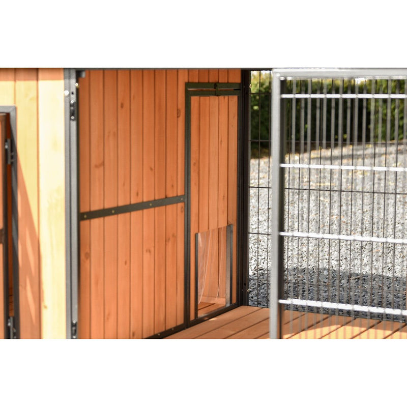 Holztür eines Hundezwingers mit Metallrahmen neben einem Gitterzaun im Aussenbereich.