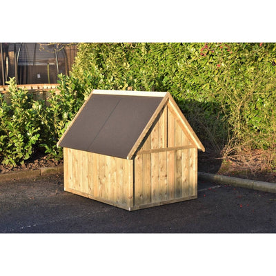 Holz-Hundehütte im Garten mit dunklem, schrägem Dach auf Asphalt, vor grüner Hecke.