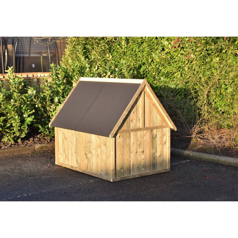 Holz-Hundehütte im Garten mit dunklem, schrägem Dach auf Asphalt, vor grüner Hecke.